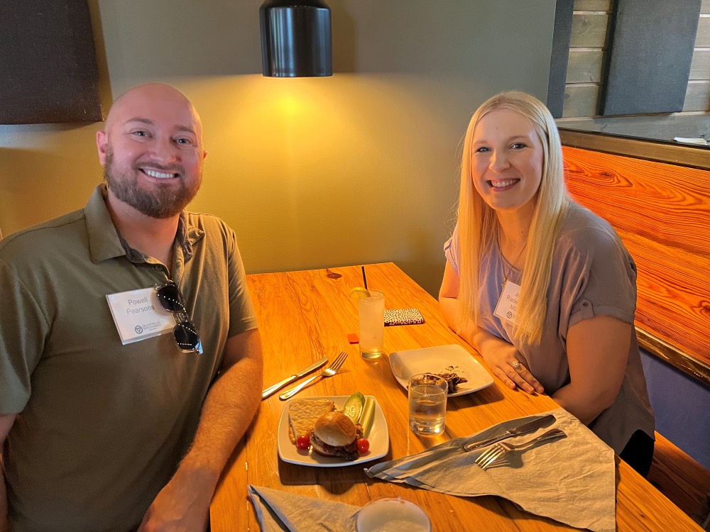 GVSU Alumni smile in booth after eating dinner together